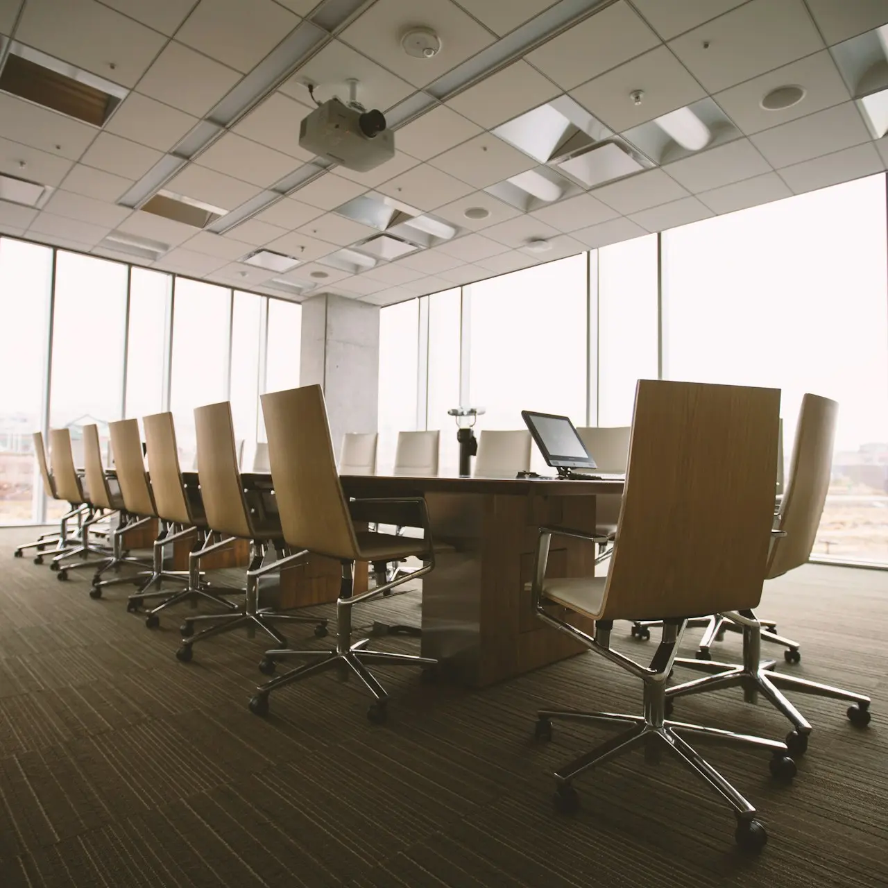 oval brown wooden conference table and chairs inside conference room