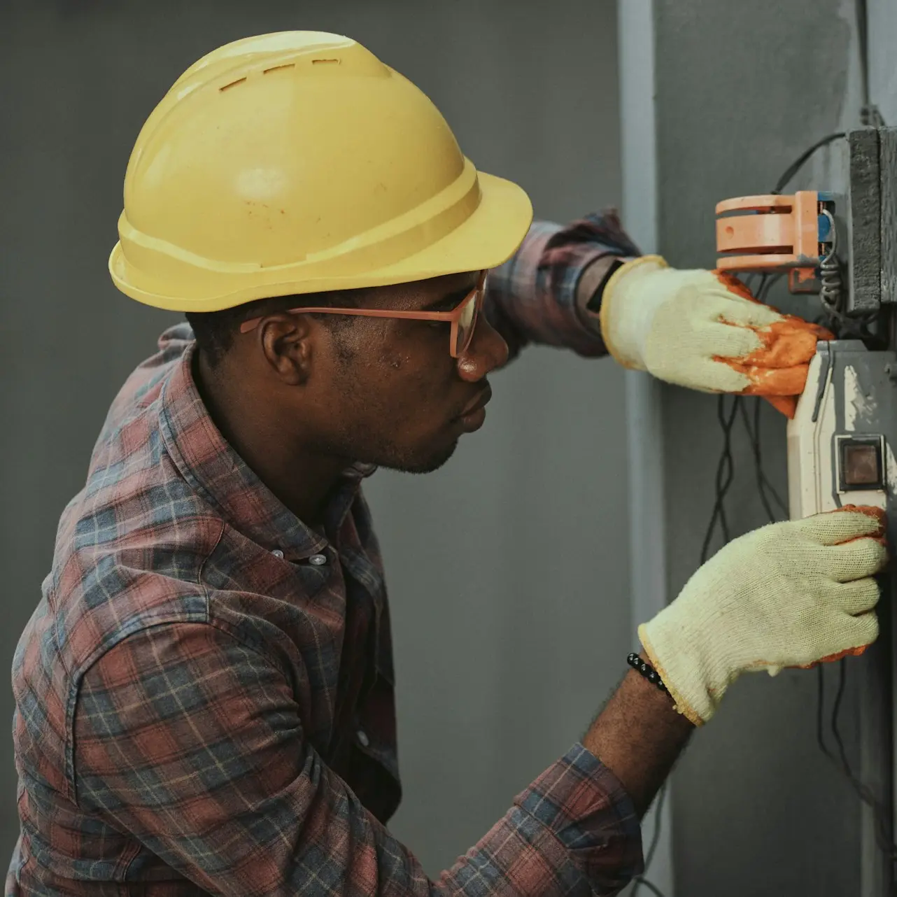 man in brown hat holding black and gray power tool